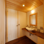 お気に入りのタイルを貼った洗面所 一枚板の洗面台と奥はトイレ