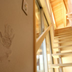 塗り壁に記念の手形、圧迫感のないスケルトン階段 玄関から階段を上がるとリビングへ