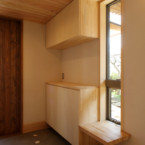 玄関には造り付け収納と腰掛スペースを設置 暗くなりがちな玄関に縦長の窓で明るく