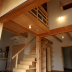 階段と一体の本棚に、洗面室への入口がある デッキより、階段と吹き抜け