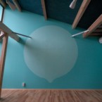 勾配天井、構造材、ムク材フロアー、そして大きな水玉? 濃紺の天井と空色の壁面に描かれたまる、のような