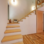 漆喰と無垢板の階段を上るとロフトにある書斎スペースへ 主寝室、壁伝いにロフトへの漆喰の階段