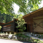 傾斜地に建つこの家は、その斜面を利用した平屋 緑あふれる季節、ルーバーとログの平屋