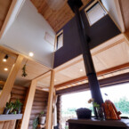 冬には家全体を暖めてくれる大きな薪ストーブ 吹き抜けを薪ストーブの煙突が屋根へと抜けている