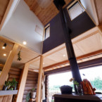 冬には家全体を暖めてくれる大きな薪ストーブ 吹き抜けを薪ストーブの煙突が屋根へと抜けている