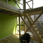 南側全面に設けられた大きな開口、風と光を部屋いっぱいに取り込む 大きな窓と草色の部屋、階段を上るとロフトへ